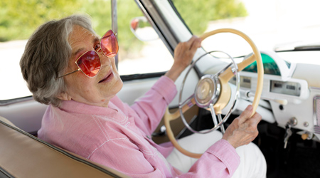Elderly woman smiling while driving