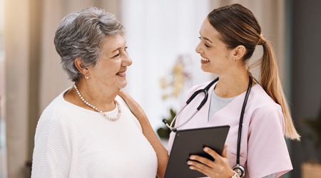 13-medical-dental-vision young female medical professional smiling and placing hand on shoulder of senior woman